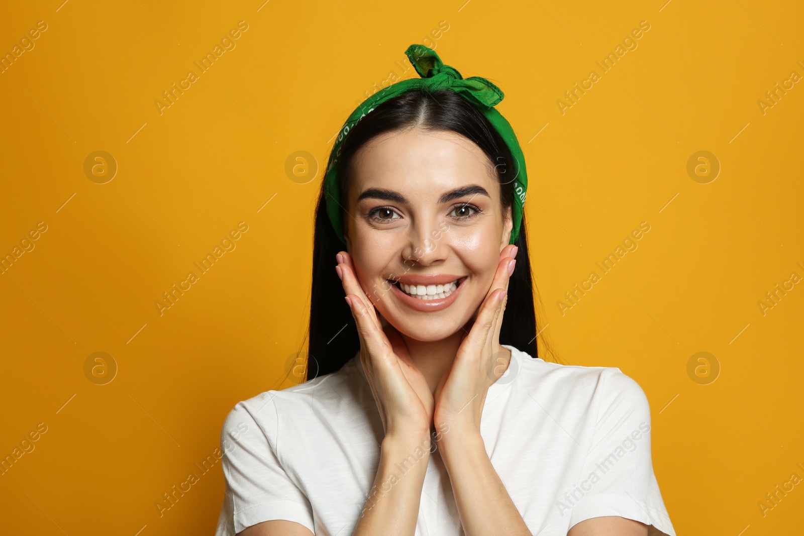 Photo of Young woman wearing stylish bandana on orange background