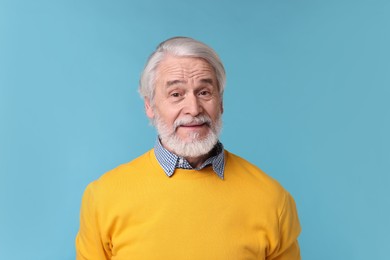 Photo of Portrait of stylish grandpa on light blue background