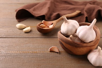 Fresh garlic on wooden table, closeup. Space for text