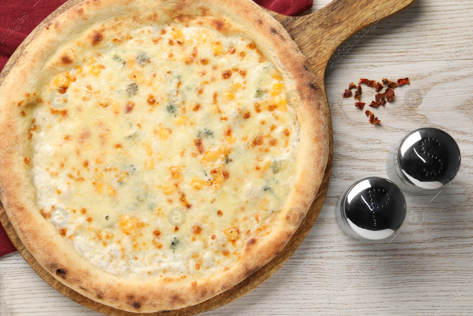 Photo of Delicious cheese pizza, salt and pepper shakers on white wooden table, flat lay