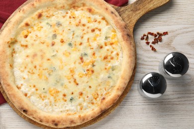 Delicious cheese pizza, salt and pepper shakers on white wooden table, flat lay