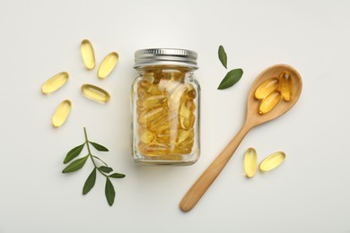 Photo of Bottle, vitamin capsules, spoon and leaves on white background, flat lay