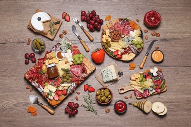 Photo of Assorted appetizers served on wooden table, flat lay