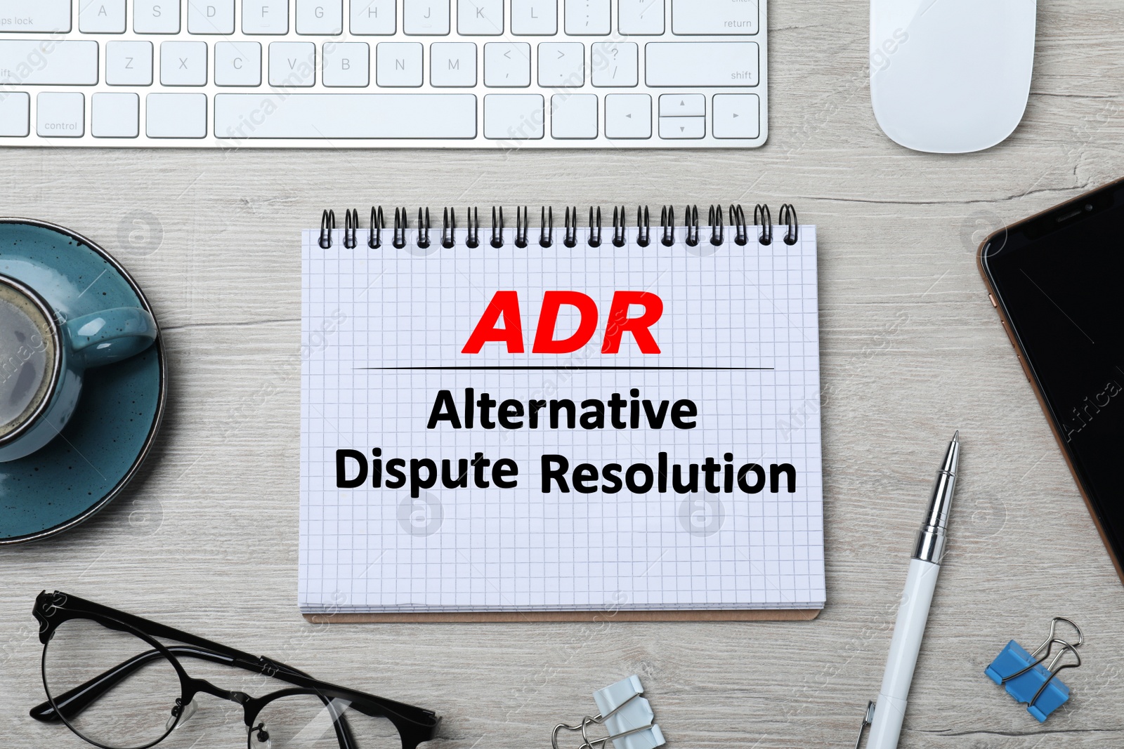 Image of Notebook with abbreviation ADR and text Alternative Dispute Resolution on wooden table, flat lay. Modern workplace