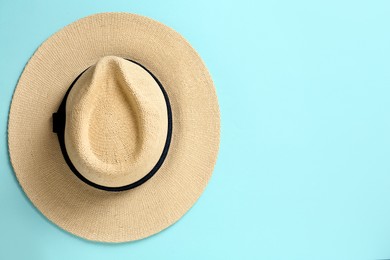 Photo of Stylish straw hat on light blue background, top view. Space for text
