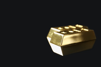 Photo of Shiny gold bars on black background. Space for text