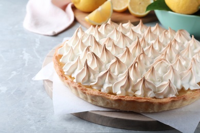 Photo of Delicious lemon meringue pie on light grey table, space for text