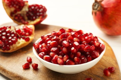 Ripe juicy pomegranate grains on white table, closeup