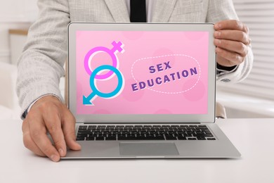 Image of Sex education program. Teacher using modern laptop at wooden table, closeup