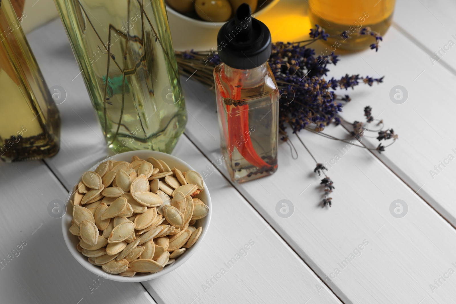 Photo of Different cooking oils and ingredients on white wooden table