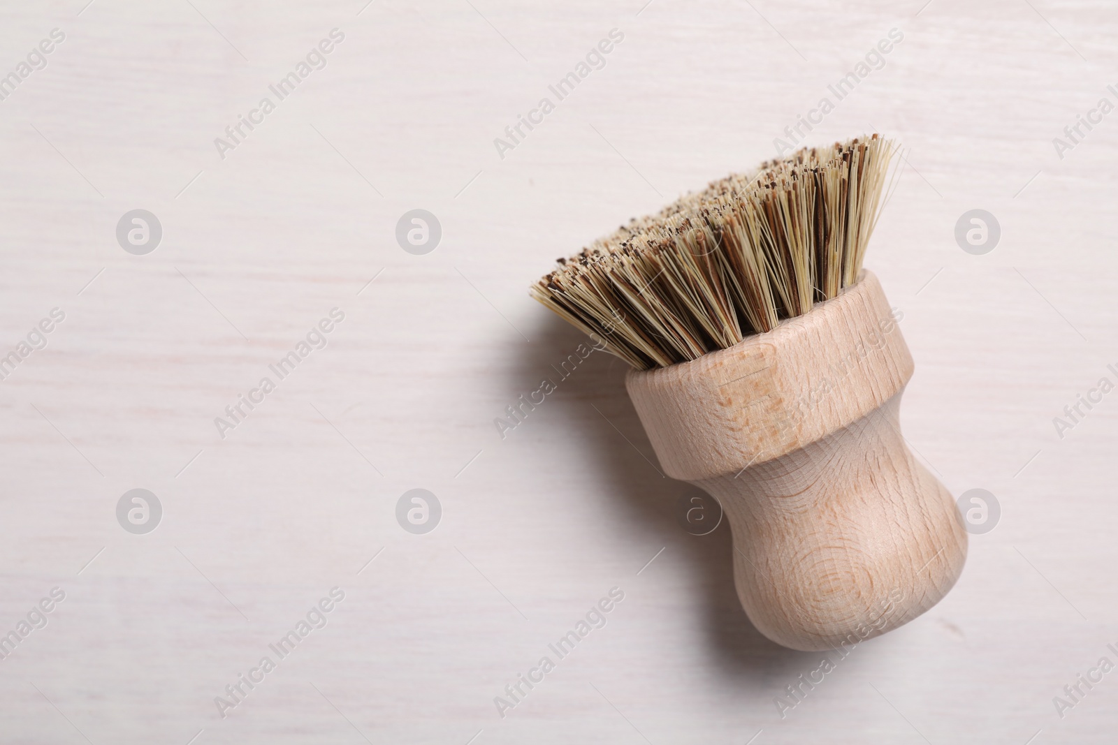 Photo of Cleaning brush on light wooden table, top view. Space for text