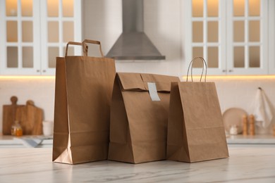 Photo of Paper bags on white marble table in kitchen