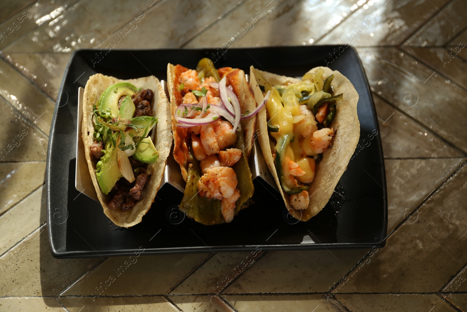 Photo of Delicious tacos with shrimps and vegetables on table, above view