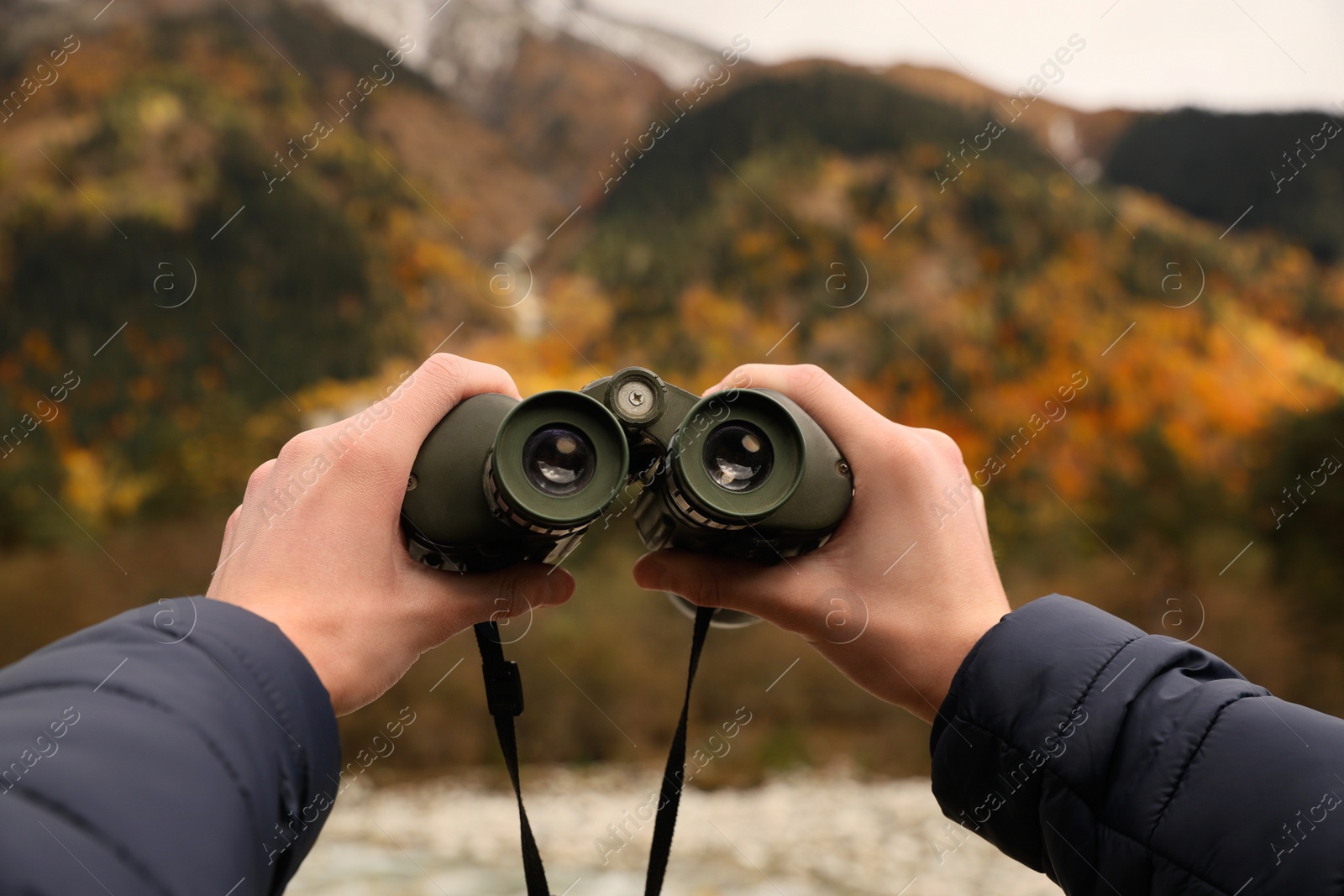 Photo of Boy holding binoculars in beautiful mountains, closeup