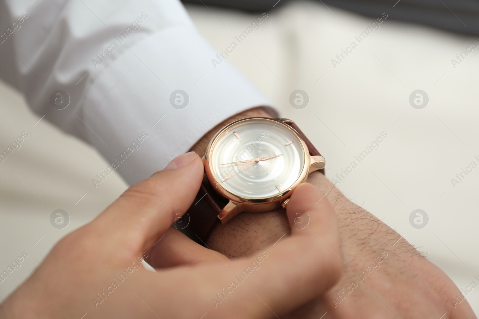 Photo of Man with luxury wrist watch on blurred background, closeup