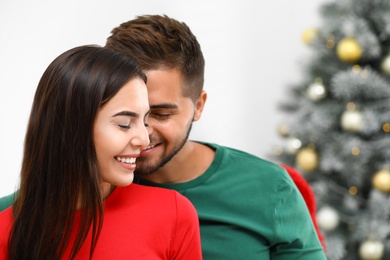 Photo of Happy young couple near Christmas tree at home