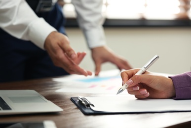 Business trainer and client working at table in office, closeup