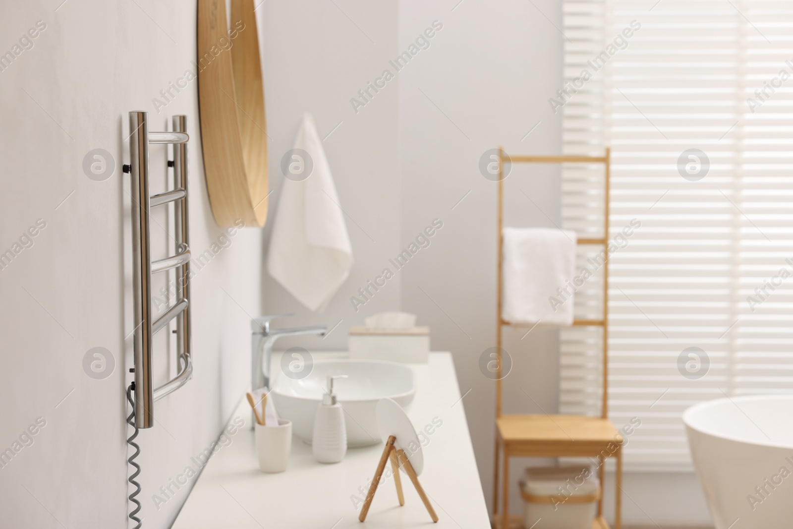 Photo of Stylish bathroom interior with heated towel rail and vanity