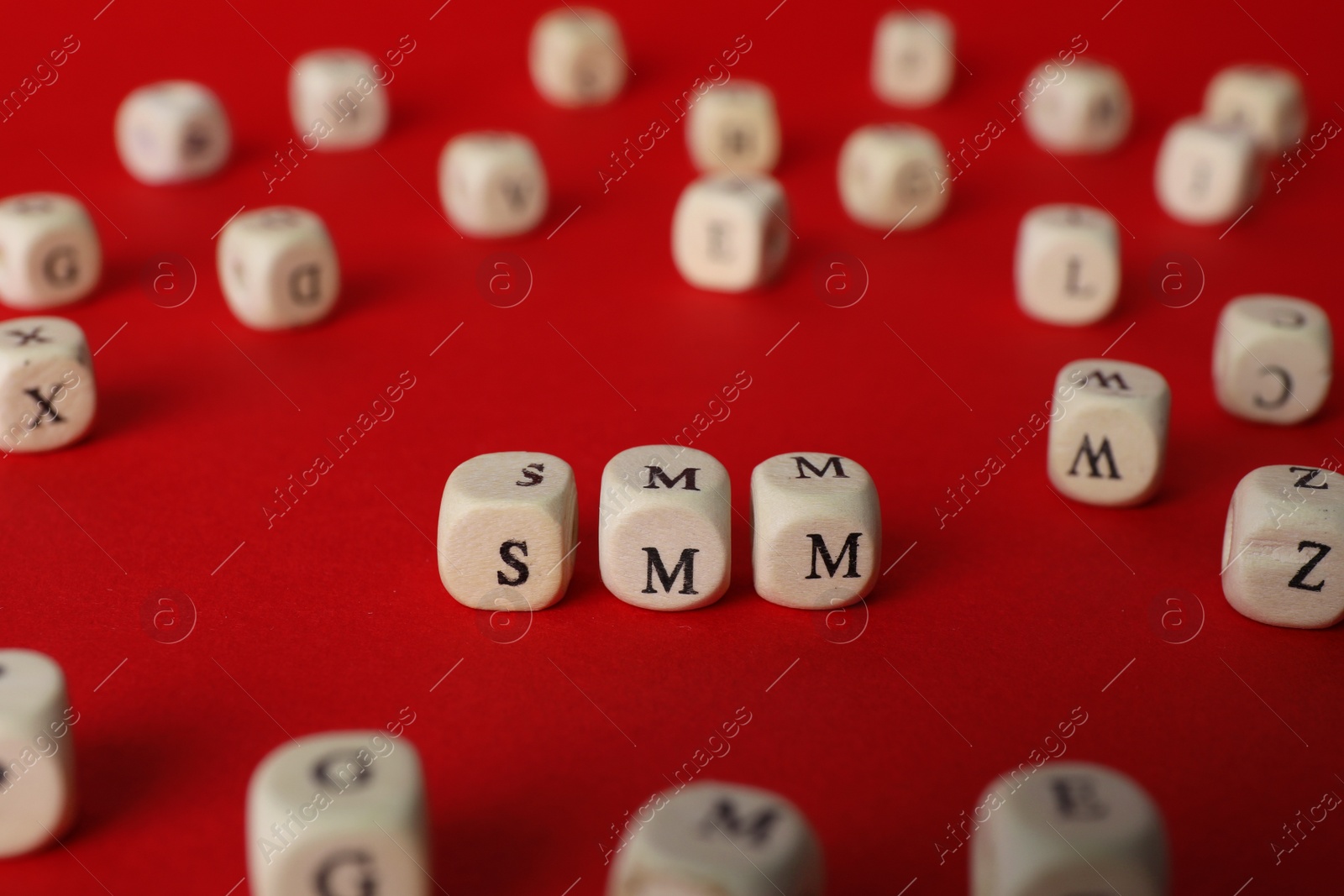Photo of Wooden cubes with abbreviation SMM (Social media marketing) on red background