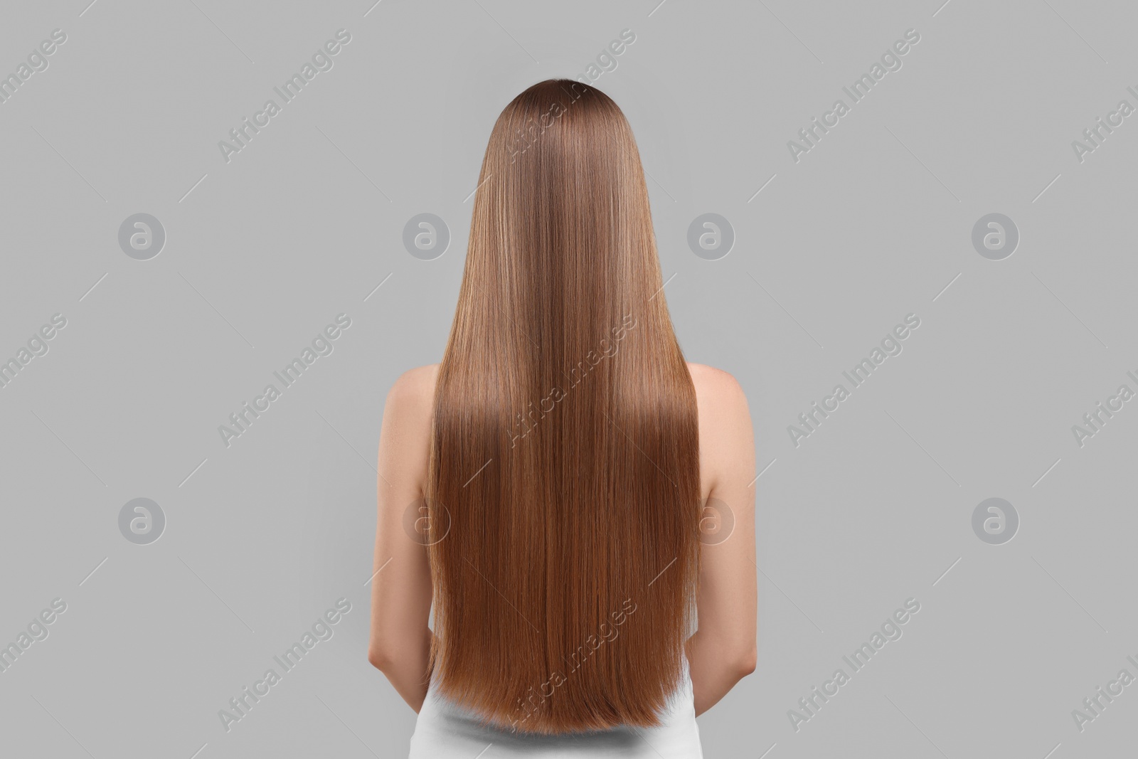 Photo of Woman with healthy hair on light grey background, back view