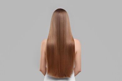 Photo of Woman with healthy hair on light grey background, back view