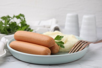 Photo of Delicious boiled sausages, mashed potato, parsley and fork on table, closeup