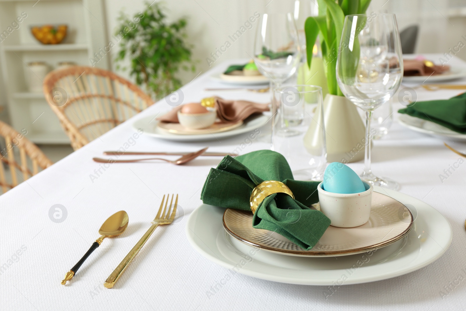 Photo of Festive Easter table setting with painted eggs indoors