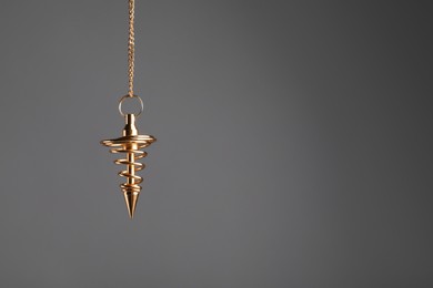 Photo of Stylish pendulum on grey background, space for text. Hypnotherapy session