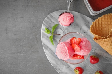 Photo of Delicious strawberry ice cream on grey  table, flat lay. Space for text