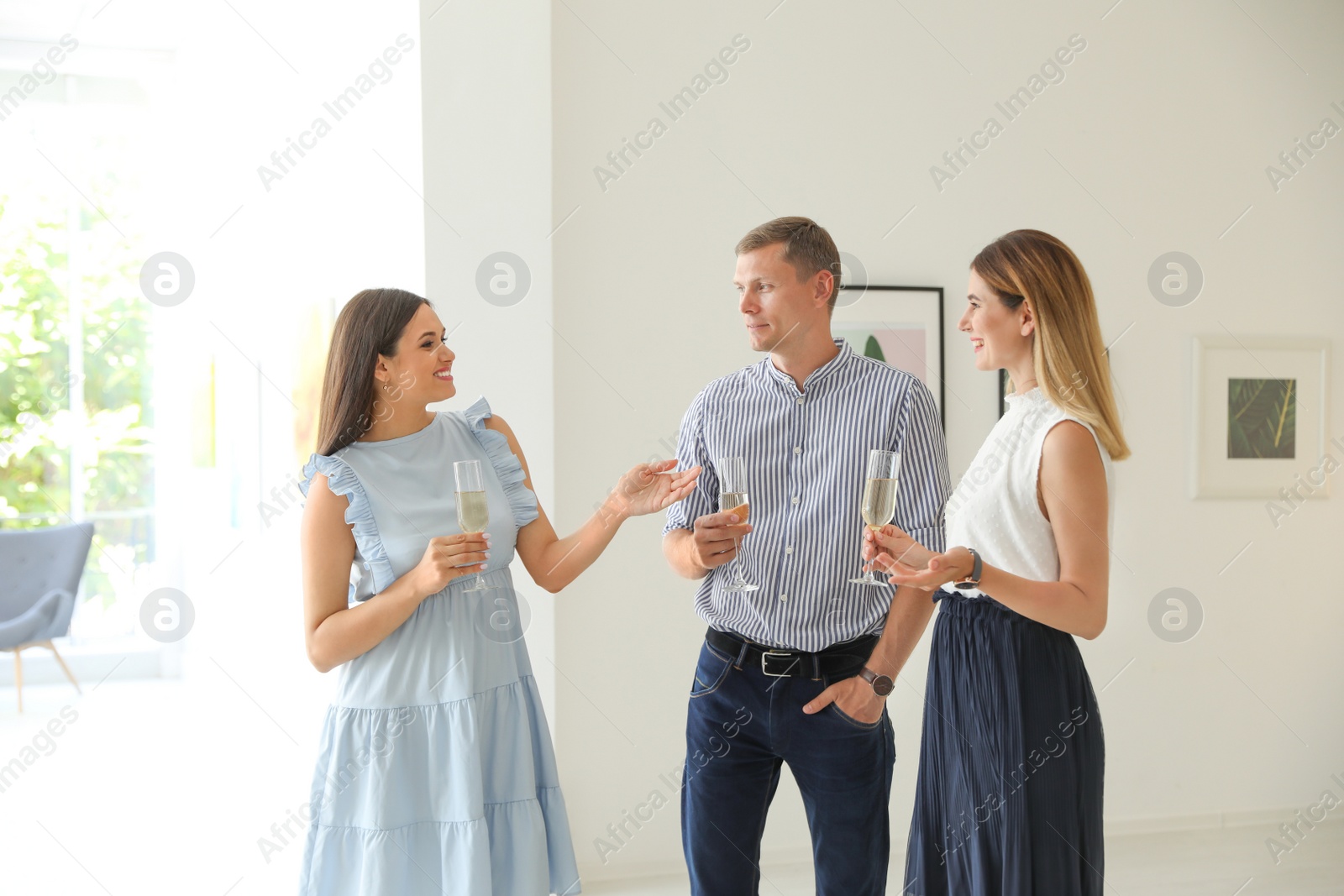 Photo of Group of people with glasses of champagne at exhibition in art gallery