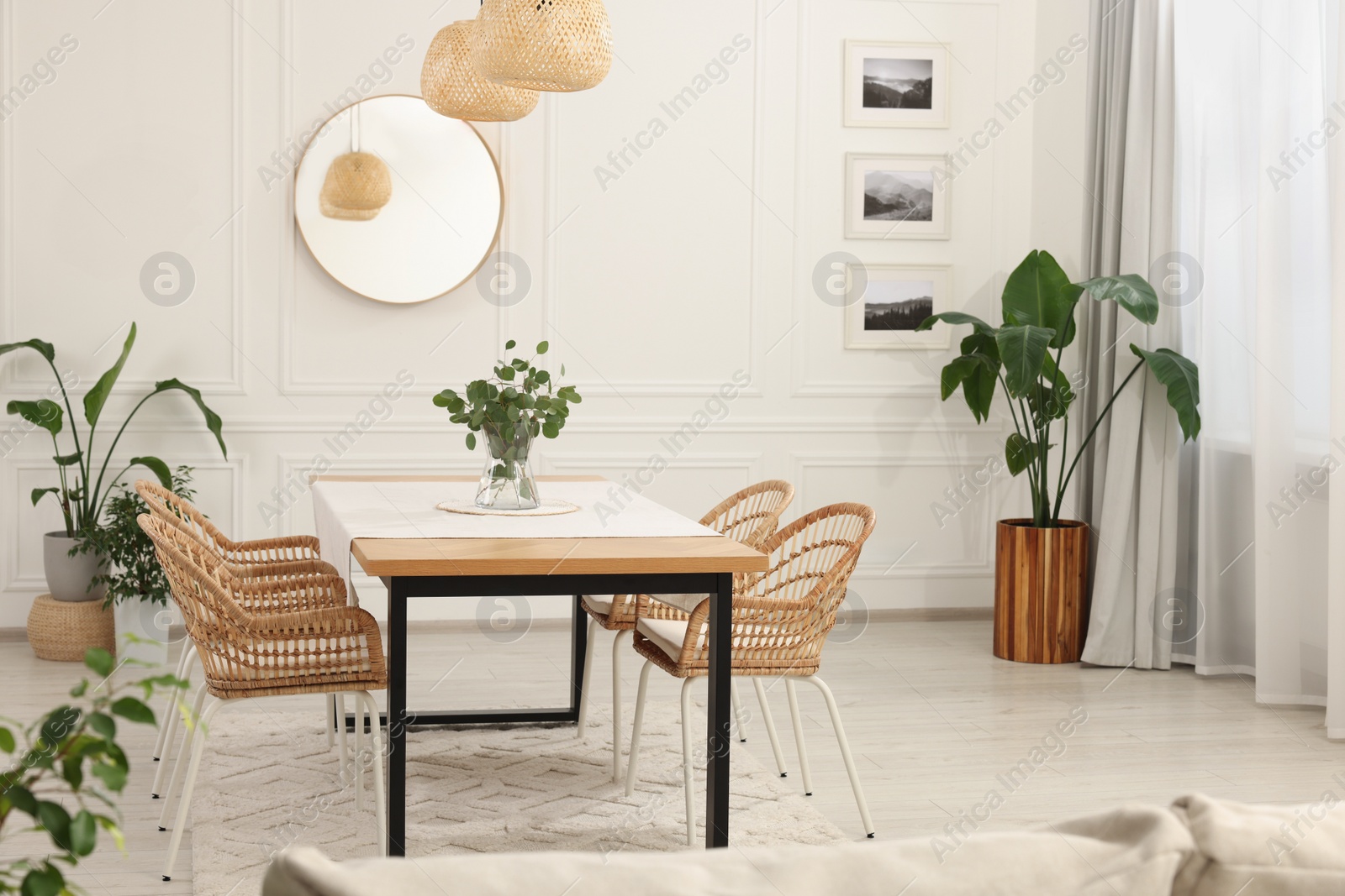 Photo of Stylish dining room with cozy furniture, mirror and plants