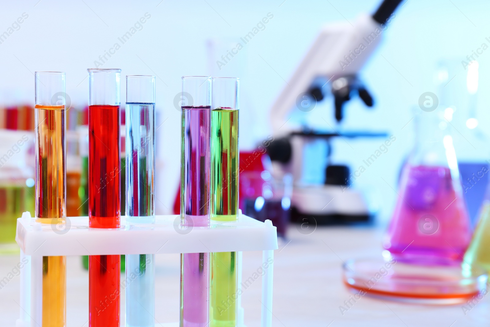 Photo of Test tubes with samples in rack on table, closeup and space for text. Solution chemistry