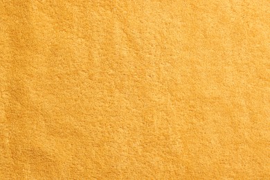 Photo of Soft orange towel as background, top view