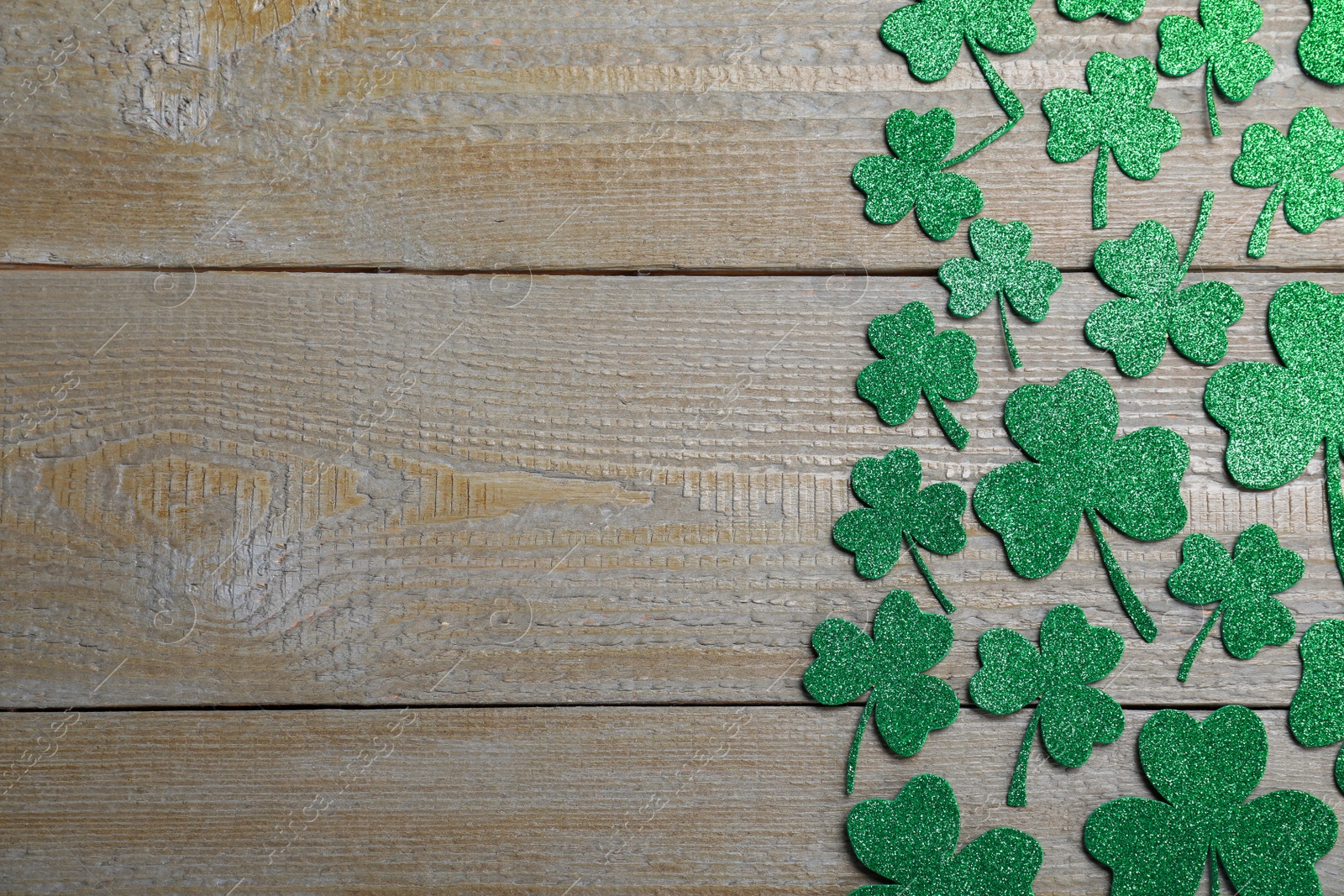 Photo of Flat lay composition with clover leaves on wooden table, space for text. St. Patrick's Day celebration