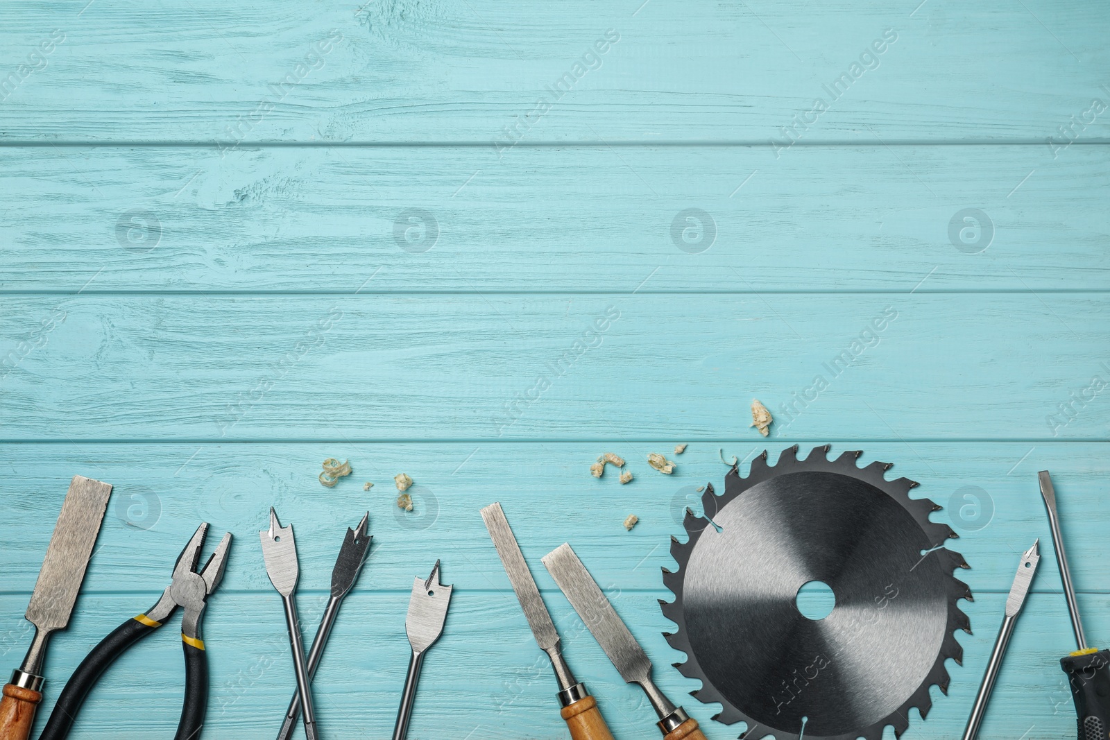 Photo of Flat lay composition with carpenter's tools on light blue wooden background. Space for text