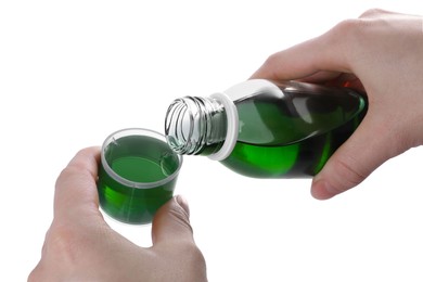 Woman pouring syrup into measuring cup from bottle isolated on white, closeup. Cough and cold medicine