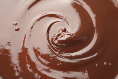 Photo of Delicious melted milk chocolate, closeup