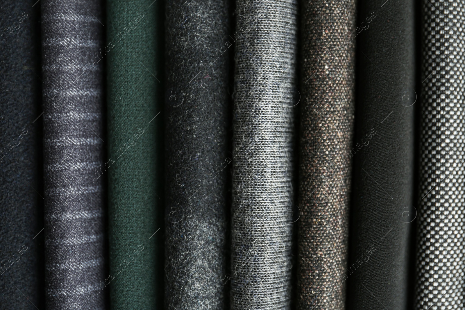 Photo of Stack of different fabric samples as background, closeup. Textile texture