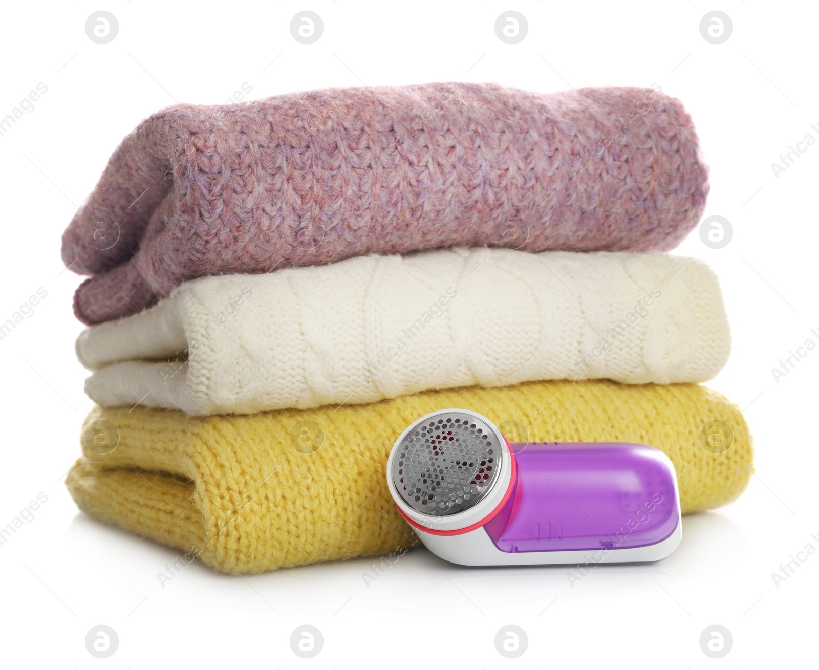 Photo of Modern fabric shaver and woolen clothes on white background