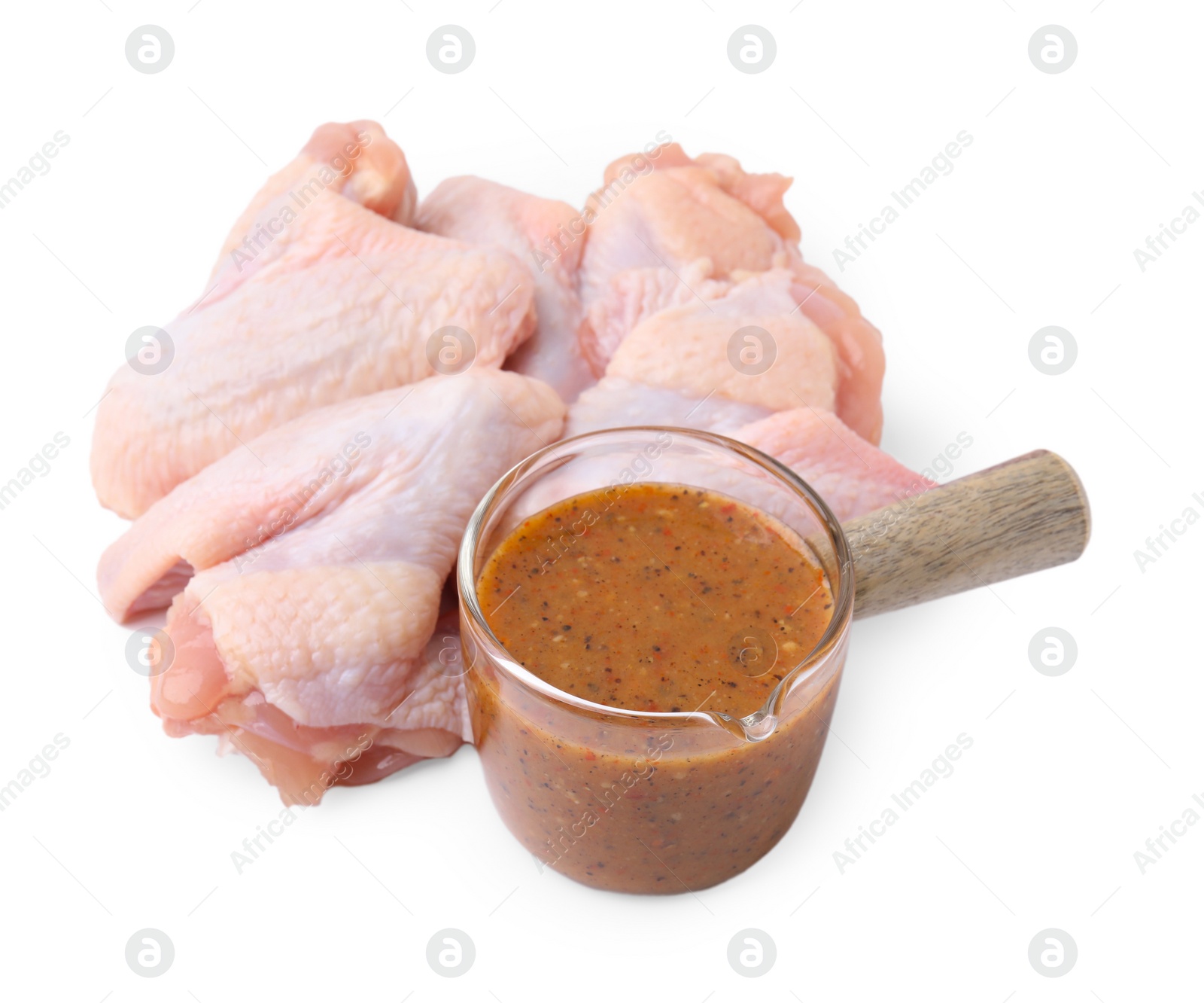 Photo of Fresh marinade and raw chicken wings isolated on white