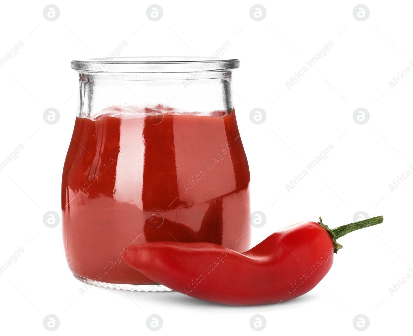 Photo of Jar with spicy chili sauce and fresh pepper on white background