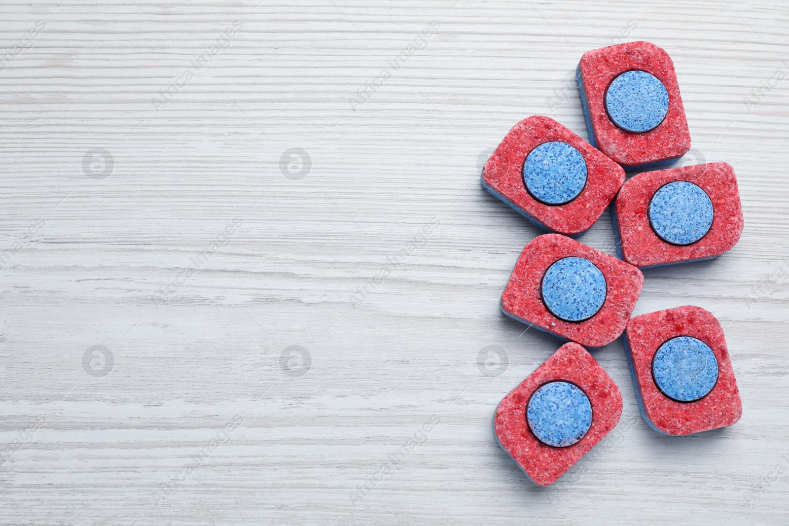 Photo of Many dishwasher detergent tablets on white wooden table, flat lay. Space for text