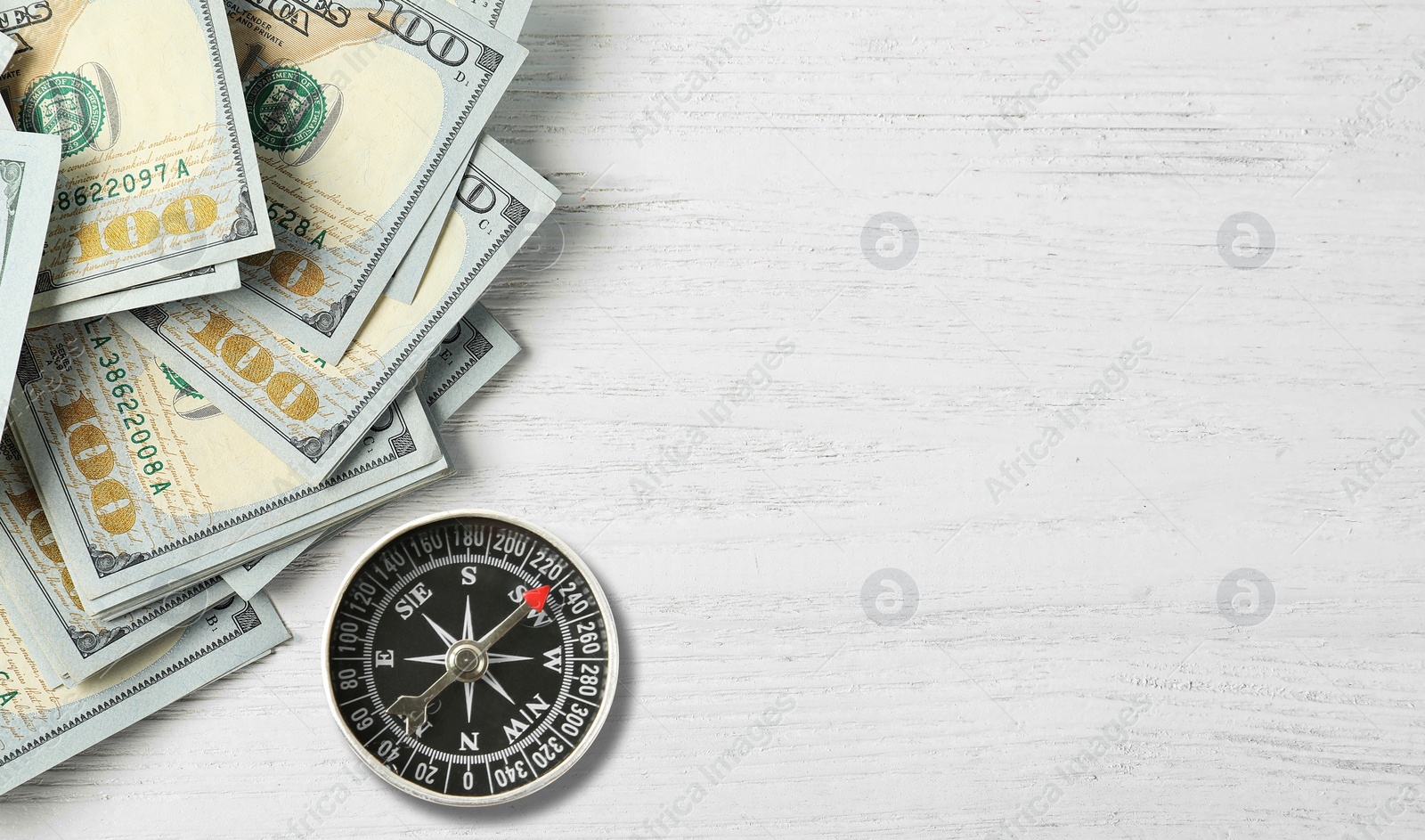 Image of Exchange rate. Money (dollar banknotes) and compass on white wooden background, flat lay. Space for text