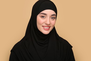Photo of Portrait of Muslim woman in hijab on beige background