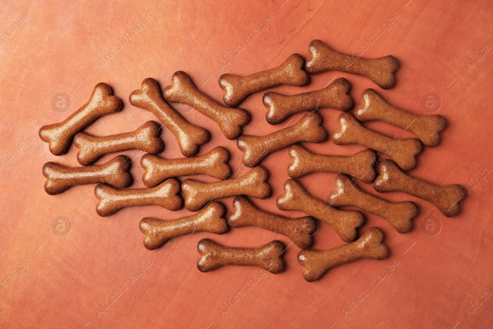 Photo of Bone shaped dog cookies on wooden background, flat lay
