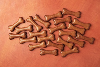 Photo of Bone shaped dog cookies on wooden background, flat lay