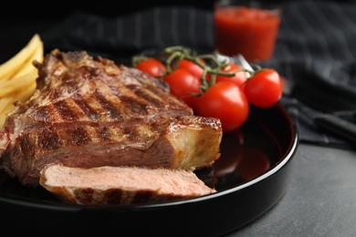 Tasty grilled steak served on black table, closeup