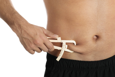 Photo of Man measuring body fat layer with caliper on white background, closeup. Nutritionist's tool