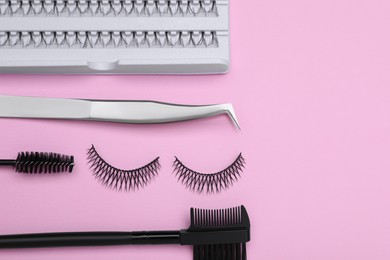 Photo of Flat lay composition with fake eyelashes on pink background, space for text