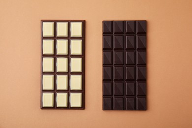 Tasty chocolate bars on brown background, flat lay